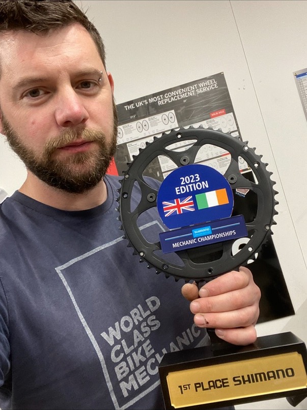 Dan holding his first-place Shimano Mechanic Championships trophy