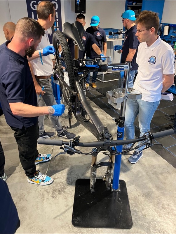 Dan and fellow mechanics working on a bike in a workshop